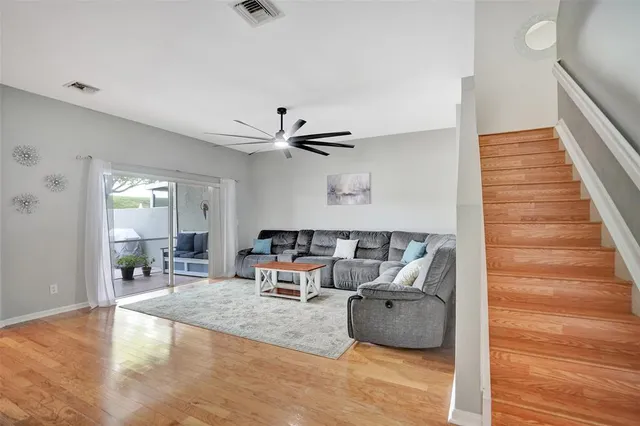 a living room with furniture and a wooden floor