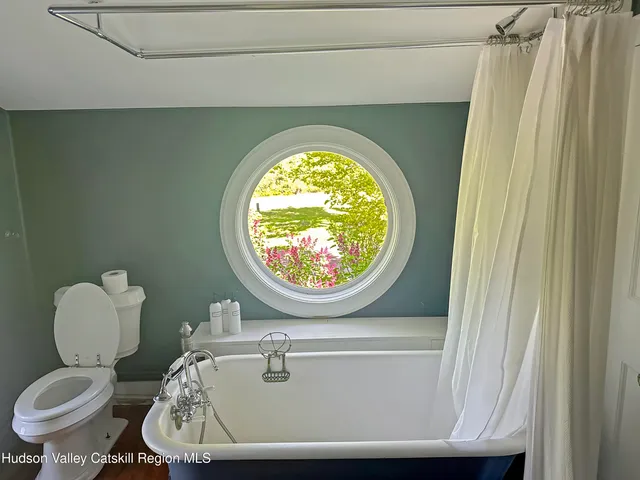 a bedroom with a large bed a flat tv screen and a fireplace