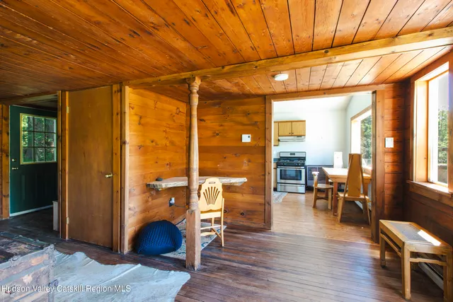 a view of a patio with table and chairs under an umbrella with large trees