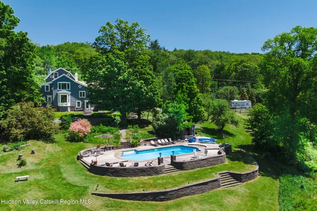 a view of a swimming pool and lounge chairs in back yard
