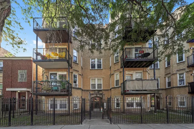 a view of a brick house with large windows and a tree