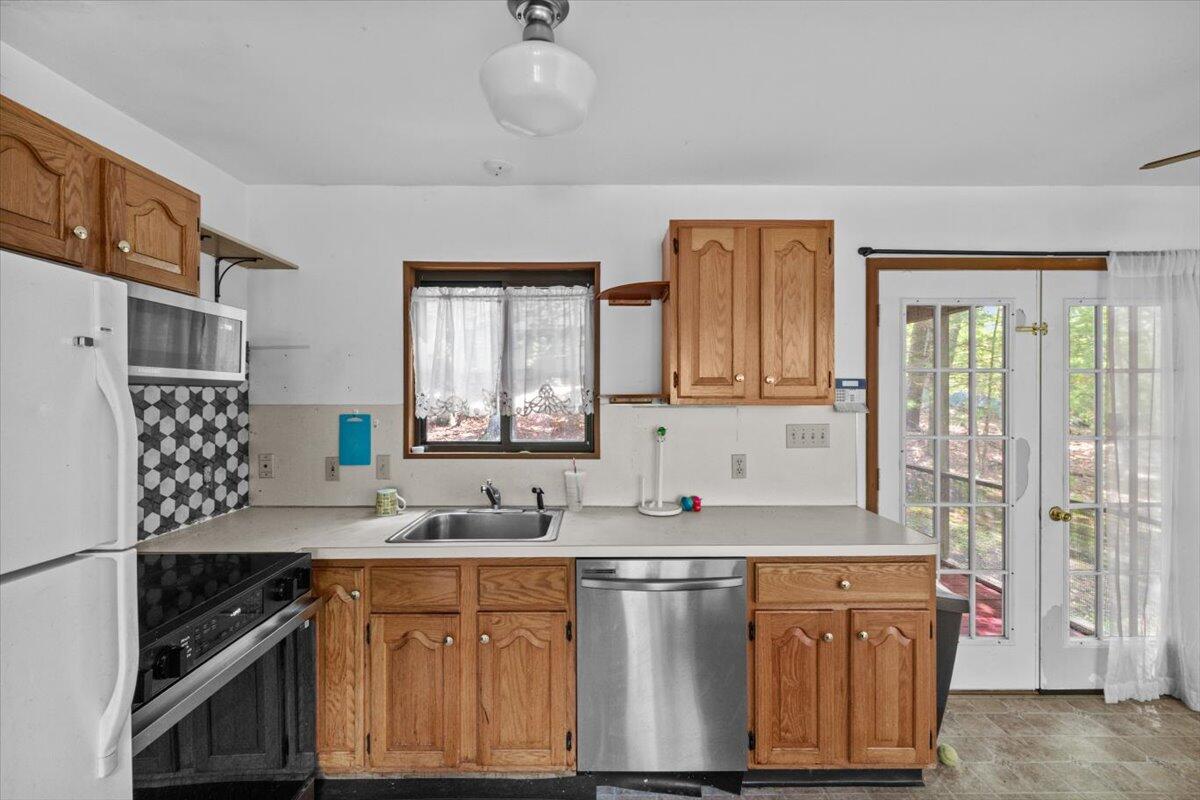 117 Manchester Drive Bushkill, PA 18324 - Photo 15 of 33 a kitchen with stainless steel appliances granite countertop a sink stove and refrigerator