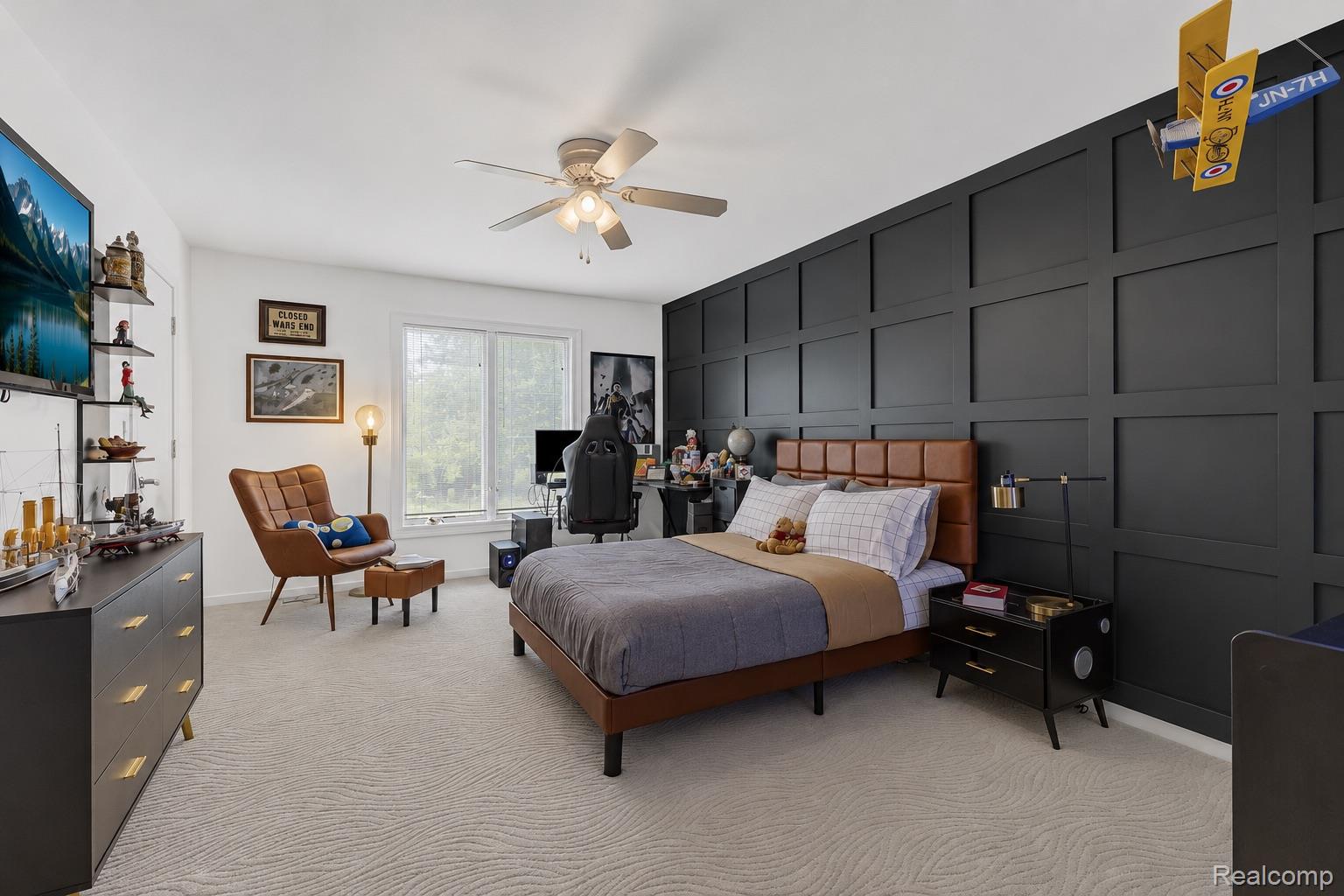69075 Brookhill Drive Romeo, MI 48065 - Photo 18 of 28 Spacious room featuring a dark panel accent wall, light patterned carpet, and large window providing natural illumination