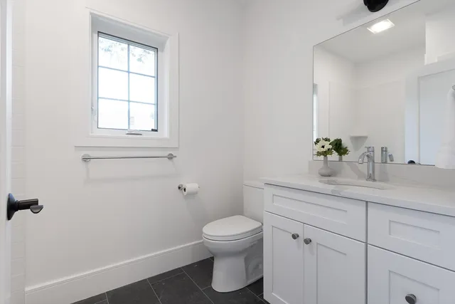 a bathroom with a toilet a sink and mirror
