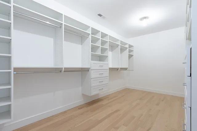 a view of walk in closet with empty racks