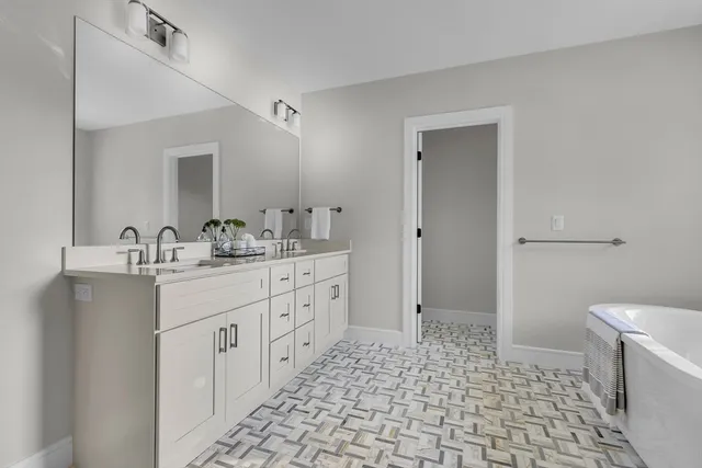 a bathroom with a sink a toilet and a large mirror