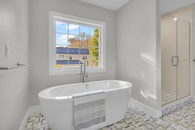 a white bath tub sitting in a bathroom next to a window