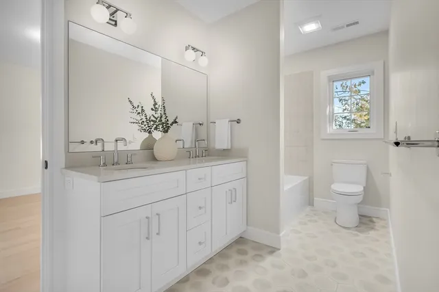 a bathroom with a granite countertop sink a toilet and a mirror