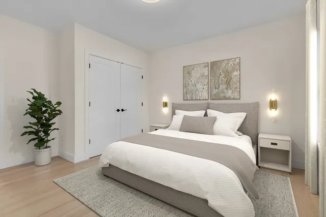 a bedroom with bed lamp and potted plant