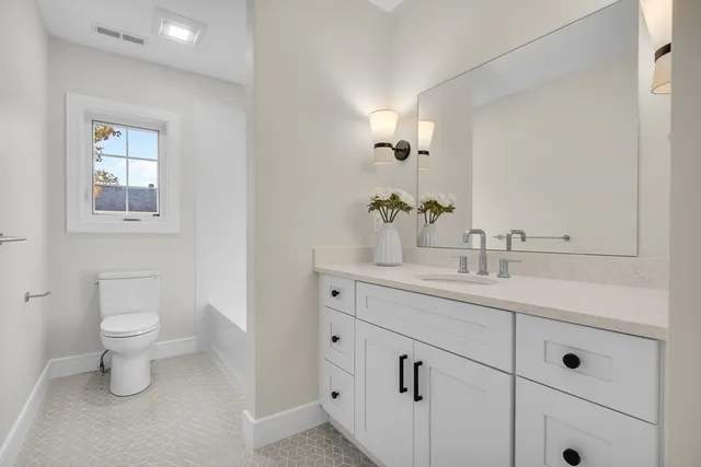 a bathroom with a toilet sink and mirror