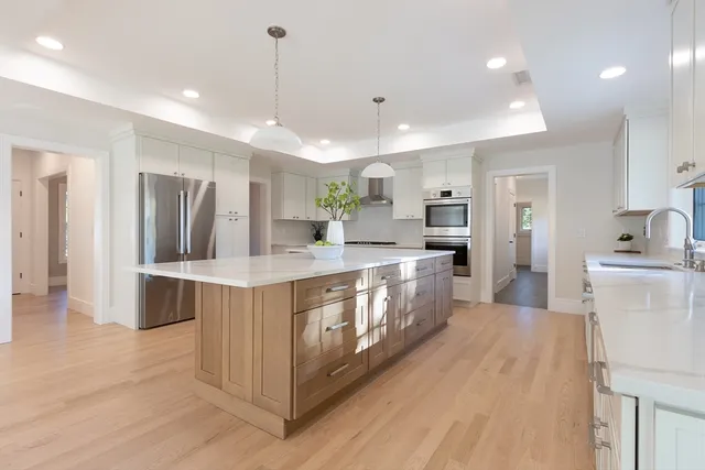 a large kitchen with stainless steel appliances lots of counter space and wooden floor