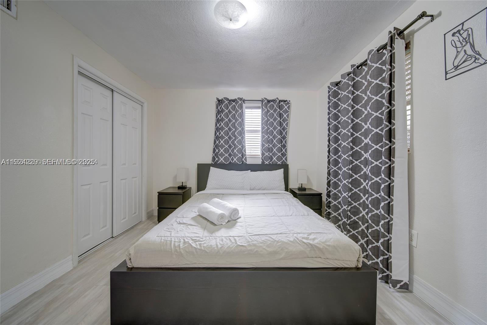 427 Southwest 6th Street, Unit 4 Miami, FL 33130 - Photo 9 of 13 a large bed sitting in a bedroom next to a small yard