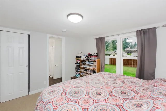 a bedroom with a bed and a large window