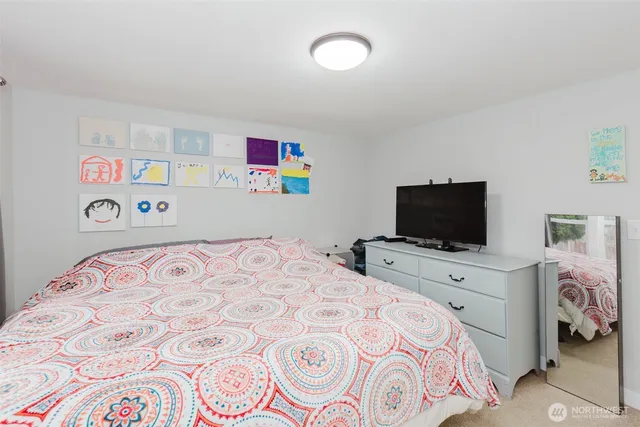 a bedroom with a bed and a television