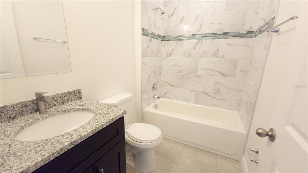 6325 Southwest 144th Lane Road Ocala, FL 34473 - Photo 27 of 31 a bathroom with a granite countertop sink toilet and shower