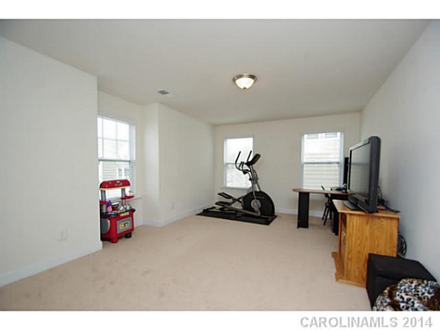 2005 Fallondale Road, Unit 921 Waxhaw, NC 28173 - Photo 14 of 16 a bedroom with furniture and a flat screen tv