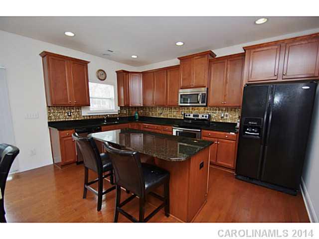 2005 Fallondale Road, Unit 921 Waxhaw, NC 28173 - Photo 4 of 16 a kitchen with stainless steel appliances granite countertop a refrigerator a sink a stove a dining table and chairs