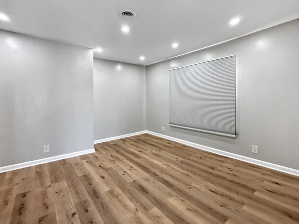 a view of empty room with wooden floor