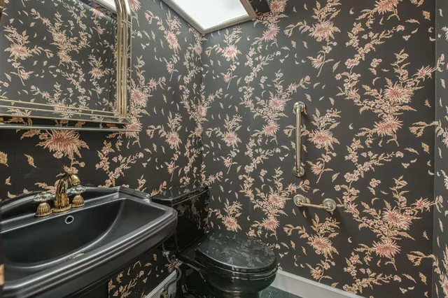 a bathroom with a granite countertop sink a toilet and mirror