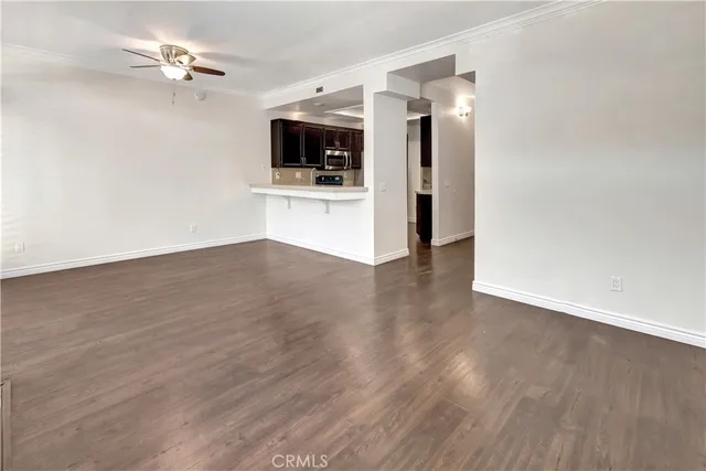 an empty room with windows fireplace and wooden floor
