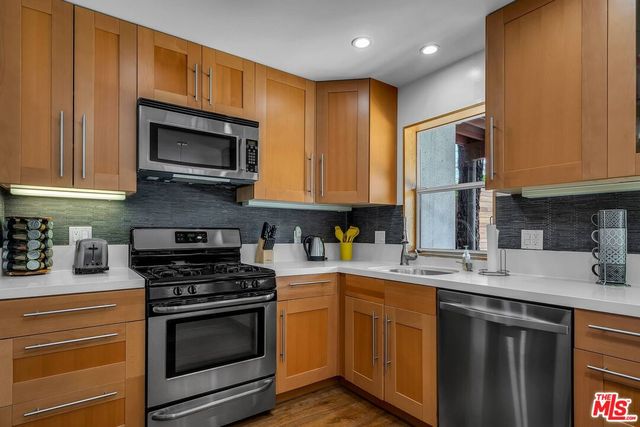 a kitchen with stainless steel appliances granite countertop a sink stove and microwave