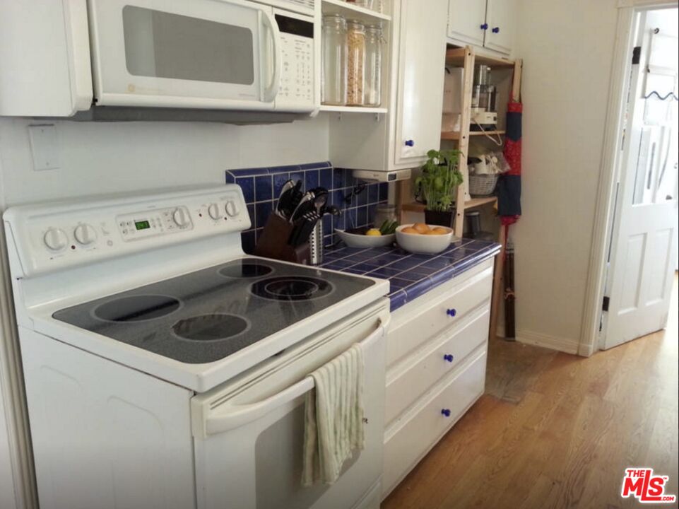 10317 Lauriston Avenue Los Angeles, CA 90025 - Photo 19 of 52 a kitchen with stainless steel appliances granite countertop white cabinets sink and stove