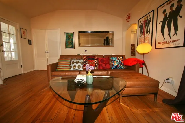 a living room with a gym equipment and wooden floor