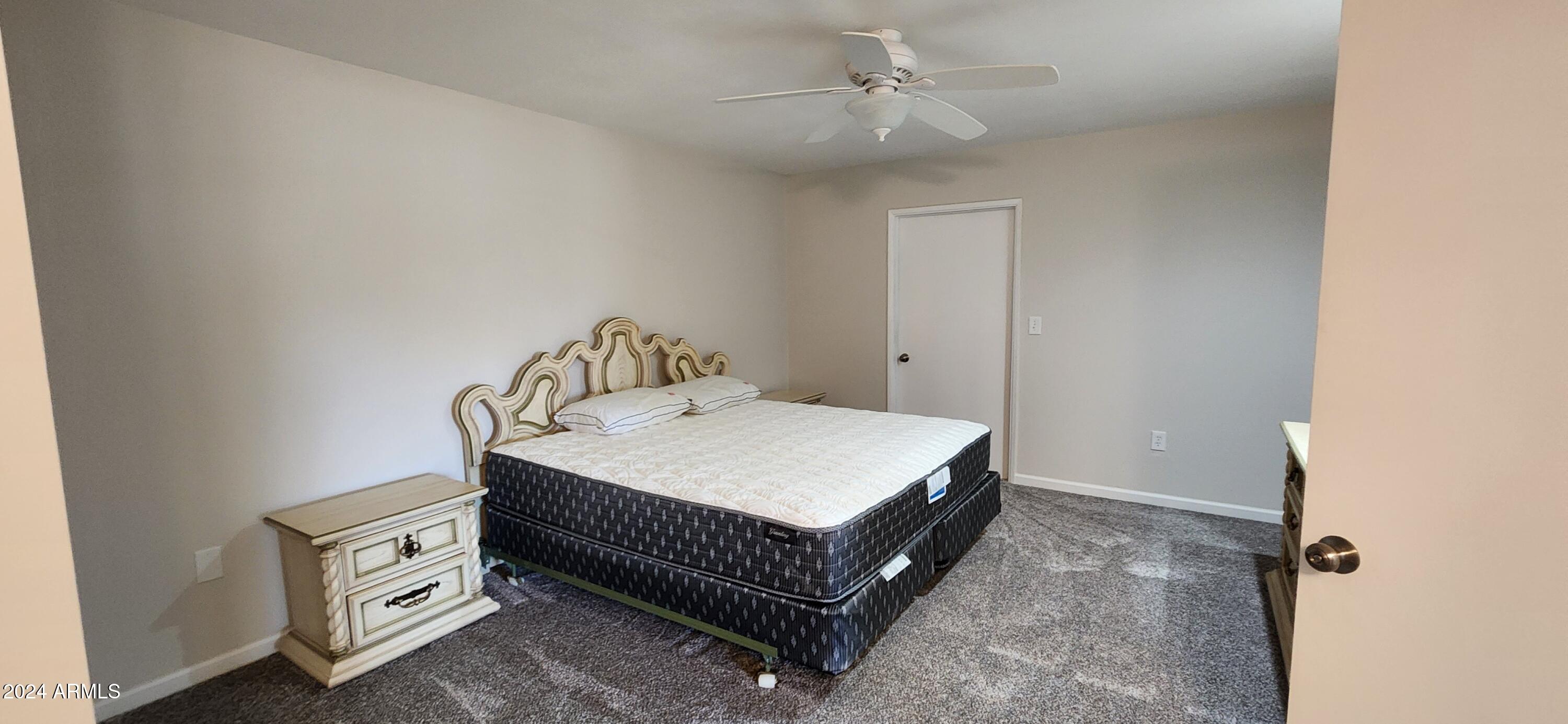 10338 West Kingswood Circle Sun City, AZ 85351 - Photo 13 of 24 a bedroom with a bed and a chandelier