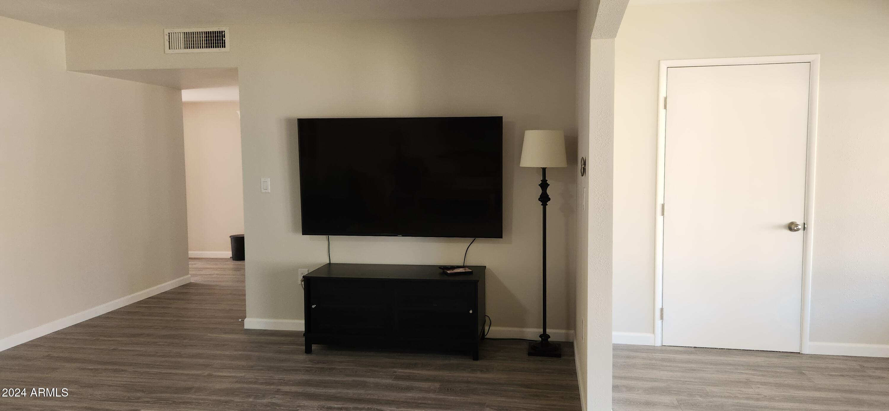 10338 West Kingswood Circle Sun City, AZ 85351 - Photo 7 of 24 a living room with a flat screen tv and a wooden floor