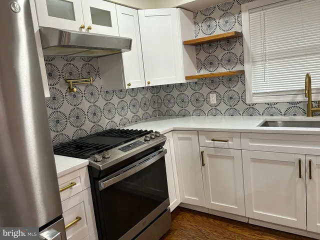 a kitchen with stainless steel appliances a stove a sink and a microwave