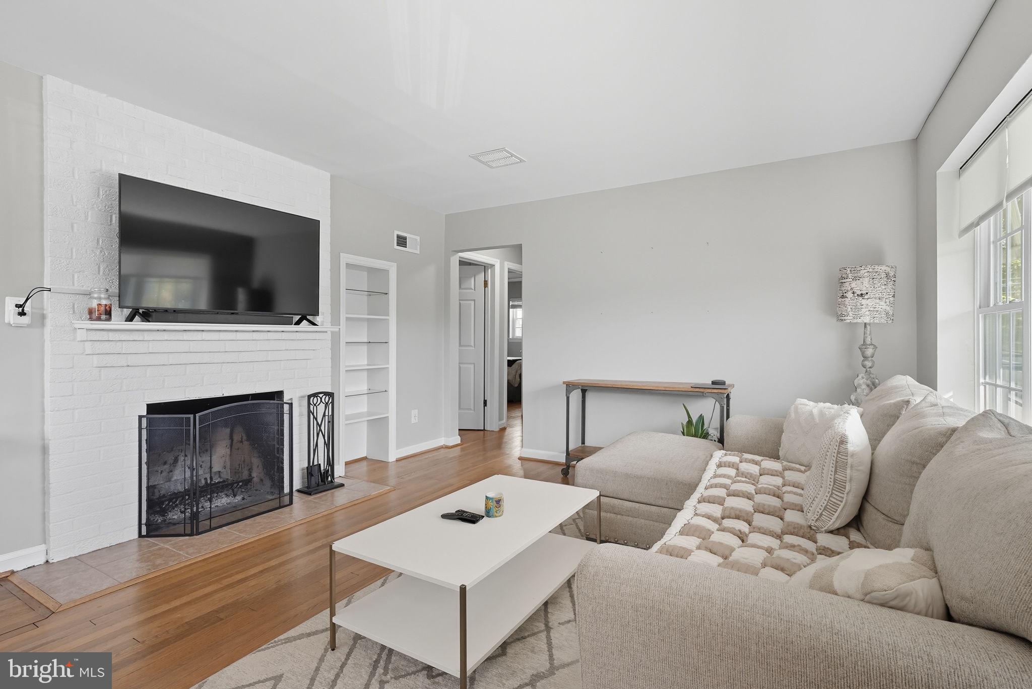 2632 North Sycamore Street Arlington, VA 22207 - Photo 3 of 26 a living room with furniture a fireplace and a flat screen tv