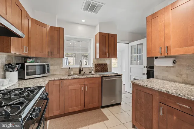a kitchen with stainless steel appliances granite countertop a stove a sink dishwasher and a refrigerator