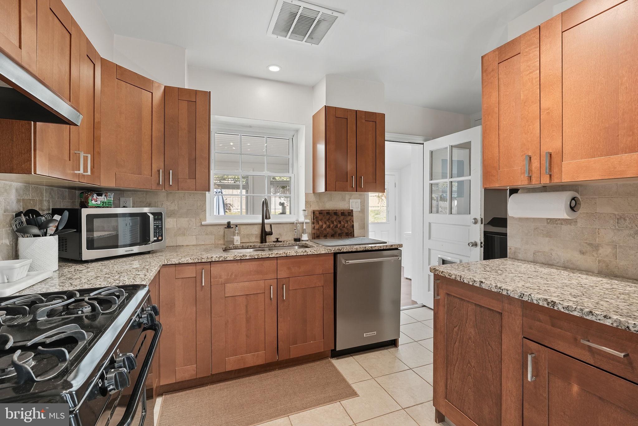 2632 North Sycamore Street Arlington, VA 22207 - Photo 8 of 26 a kitchen with stainless steel appliances granite countertop a stove a sink dishwasher and a refrigerator