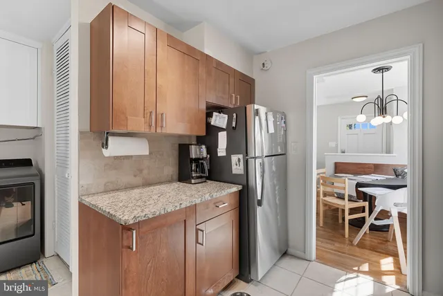 a kitchen with a refrigerator a table and chairs in it