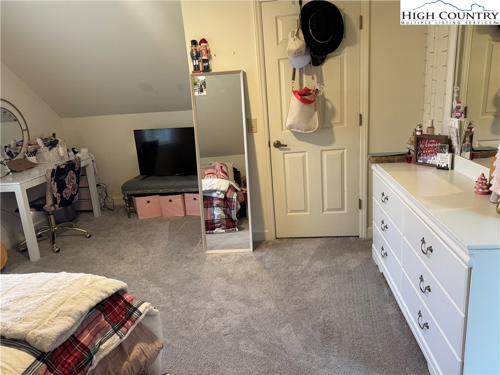 387 Tarry Acres Circle Blowing Rock, NC 28605 - Photo 27 of 41 a bedroom with a bed and a flat tv screen on the dresser