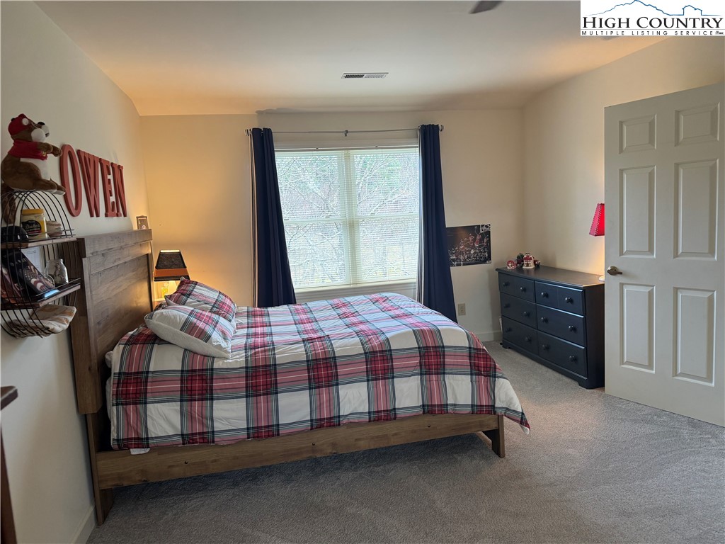 387 Tarry Acres Circle Blowing Rock, NC 28605 - Photo 29 of 41 a bedroom with a bed a dresser and a window