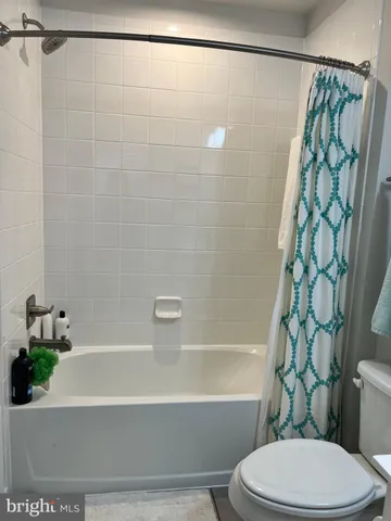 a bathroom with a bathtub shower and toilet
