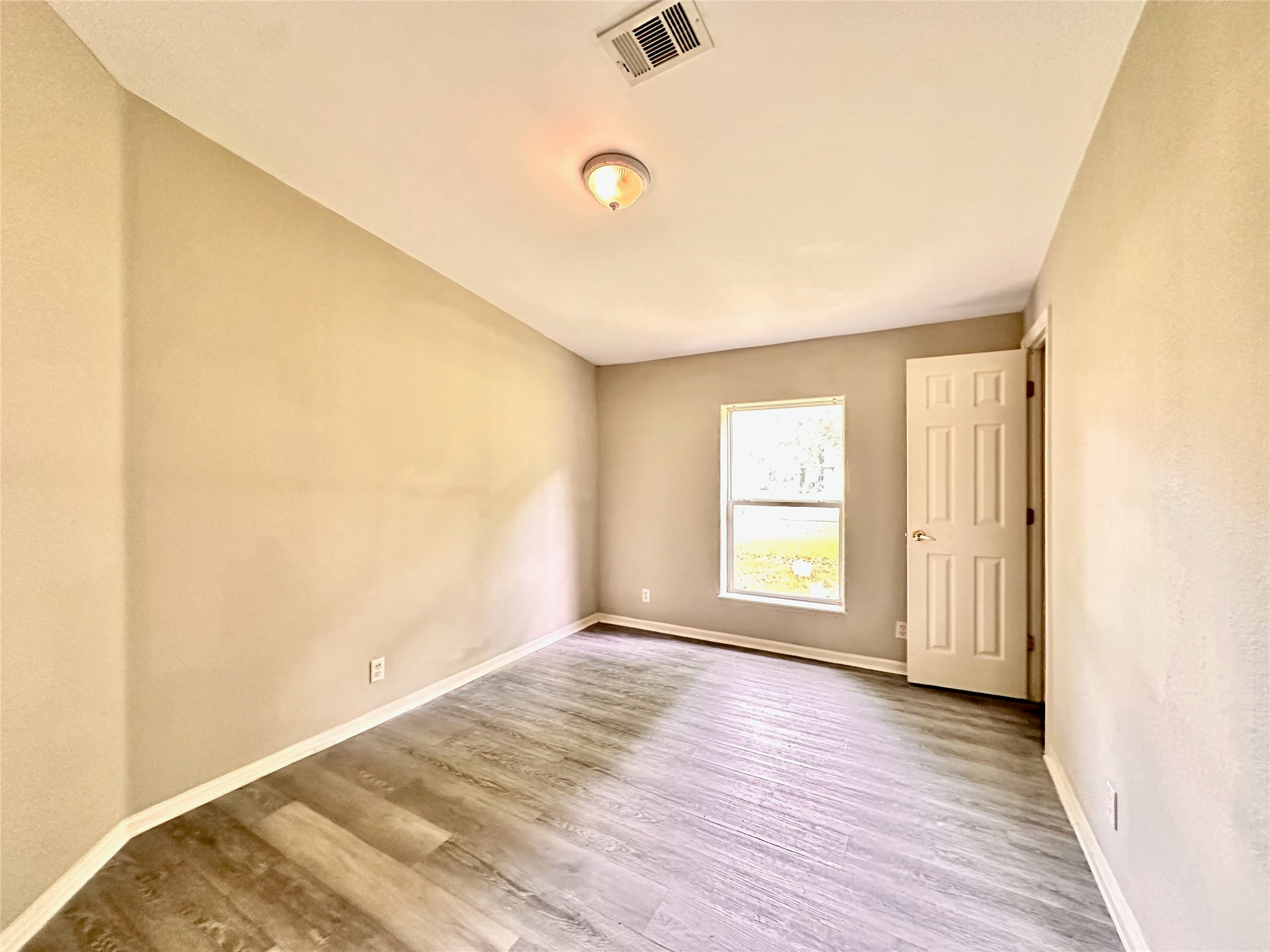 202 Main Street Fresno, TX 77545 - Photo 22 of 26 a view of an empty room with wooden floor and a window