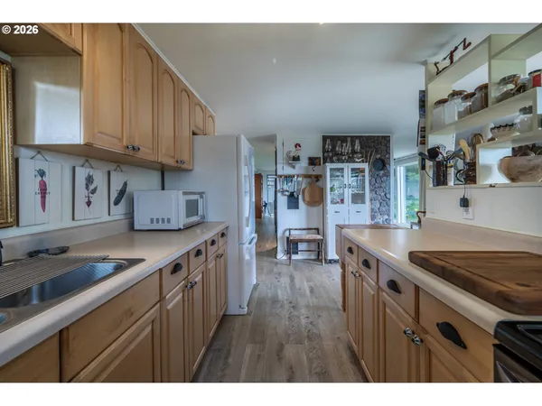 a kitchen with granite countertop a sink a stove and cabinets