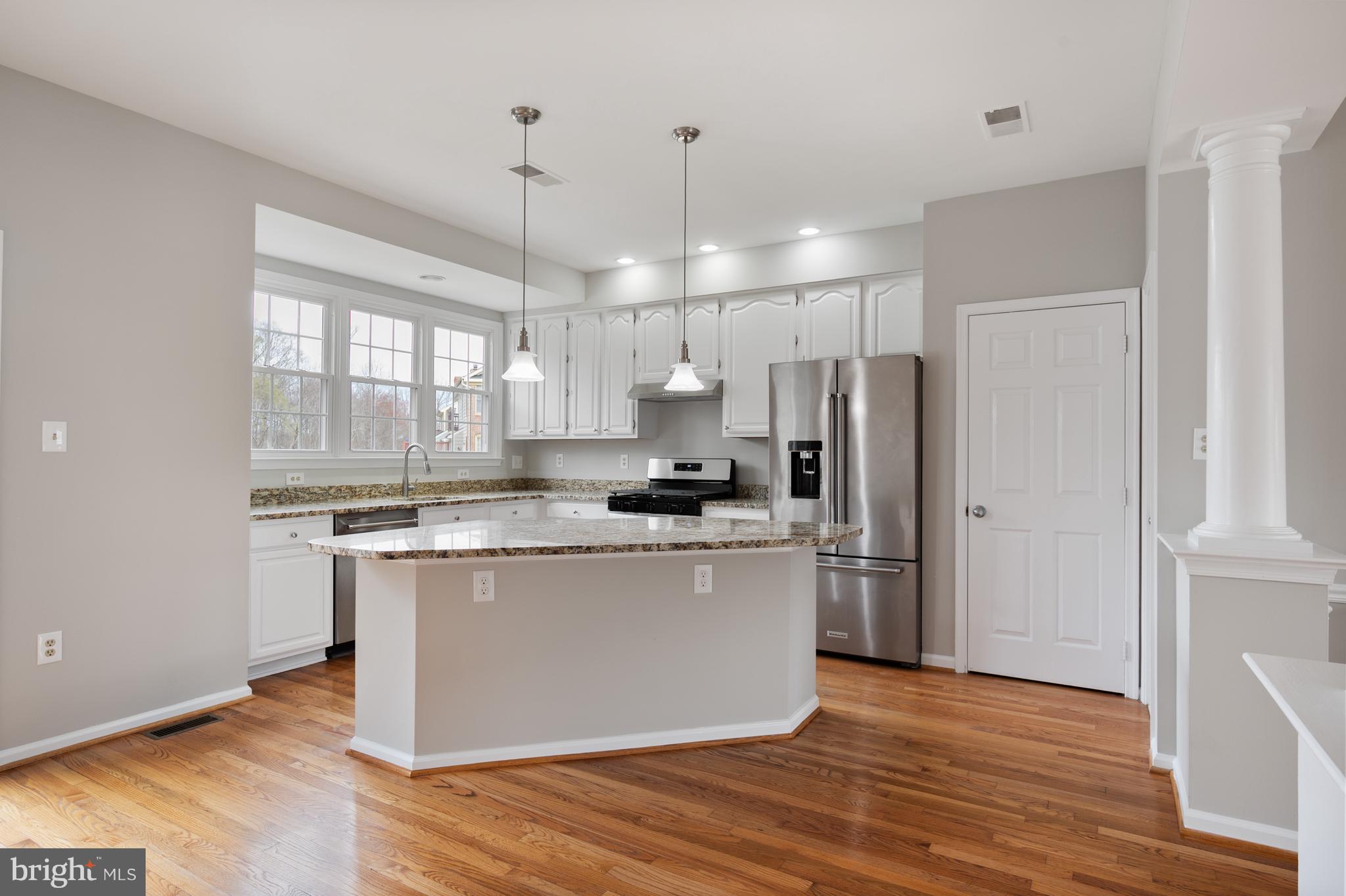 20334 Burnley Square Sterling, VA 20165 - Photo 15 of 57 a kitchen with stainless steel appliances granite countertop a refrigerator a sink dishwasher a stove and white countertops with wooden floor