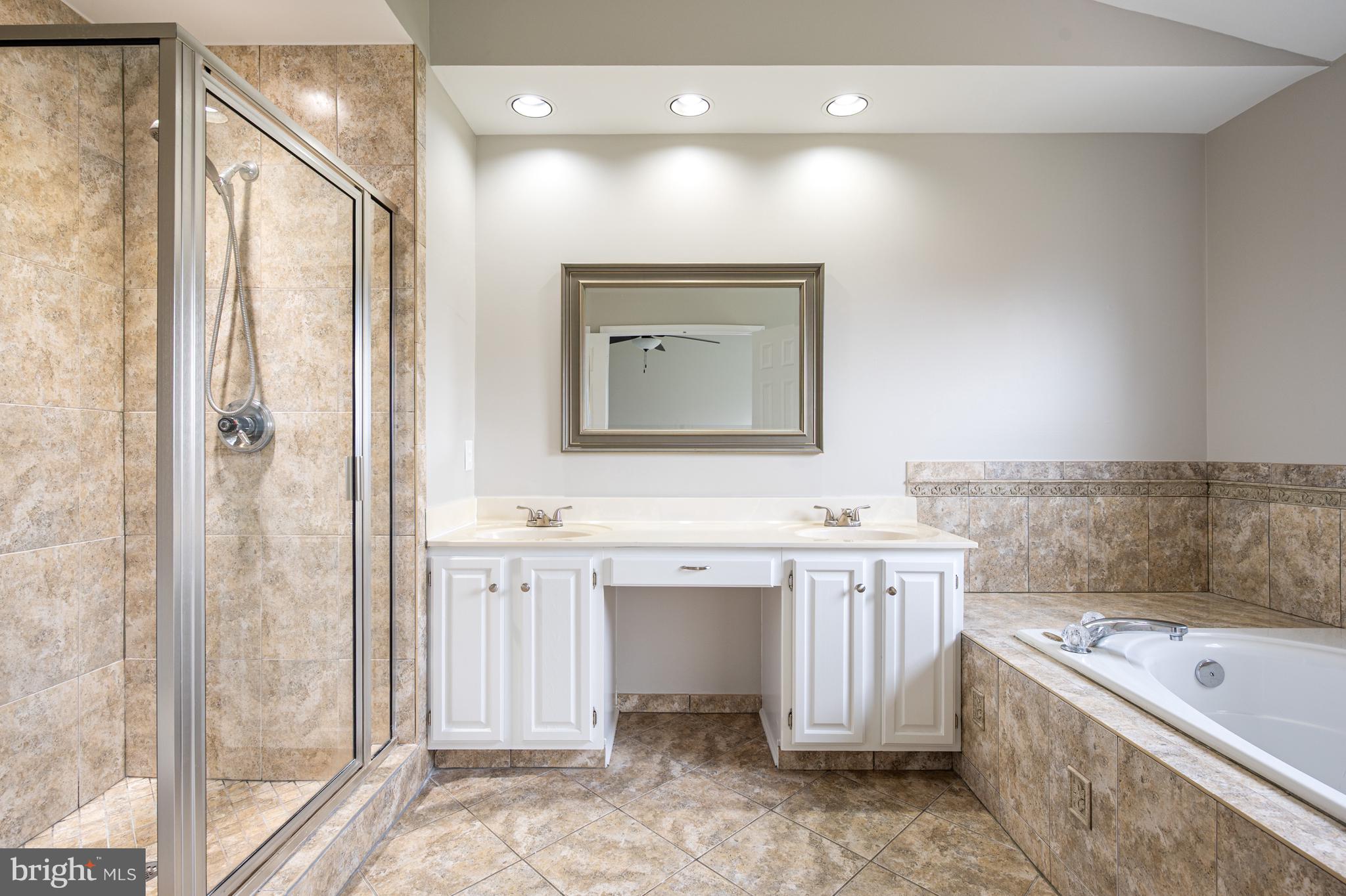 20334 Burnley Square Sterling, VA 20165 - Photo 28 of 57 a bathroom with a tub sink and mirror