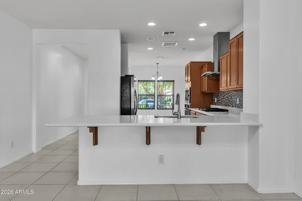a view with kitchen island a sink a counter space and cabinets