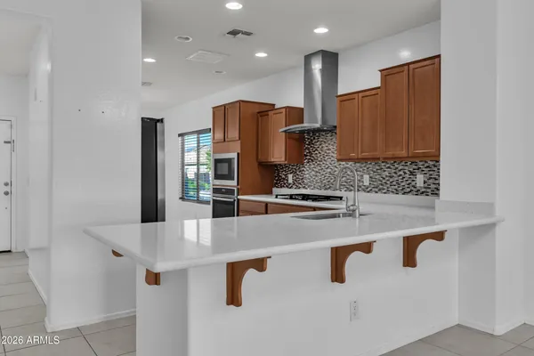 a kitchen with kitchen island granite countertop a sink and refrigerator