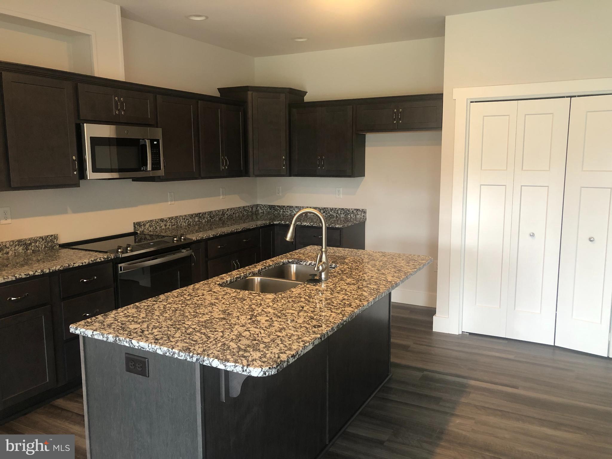 4135 Orrs Town Court, Unit 4B Mechanicsburg, PA 17050 - Photo 14 of 49 a kitchen with granite countertop a sink a stove and cabinets