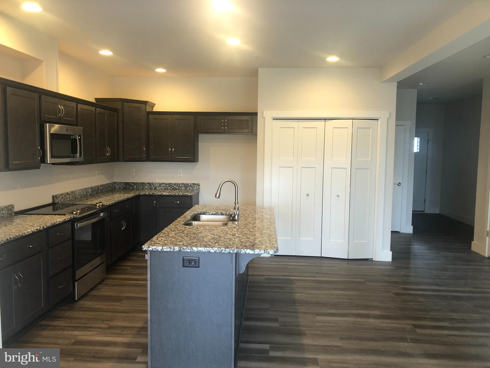 4135 Orrs Town Court, Unit 4B Mechanicsburg, PA 17050 - Photo 17 of 49 a kitchen with stainless steel appliances granite countertop a sink a stove and a wooden cabinets