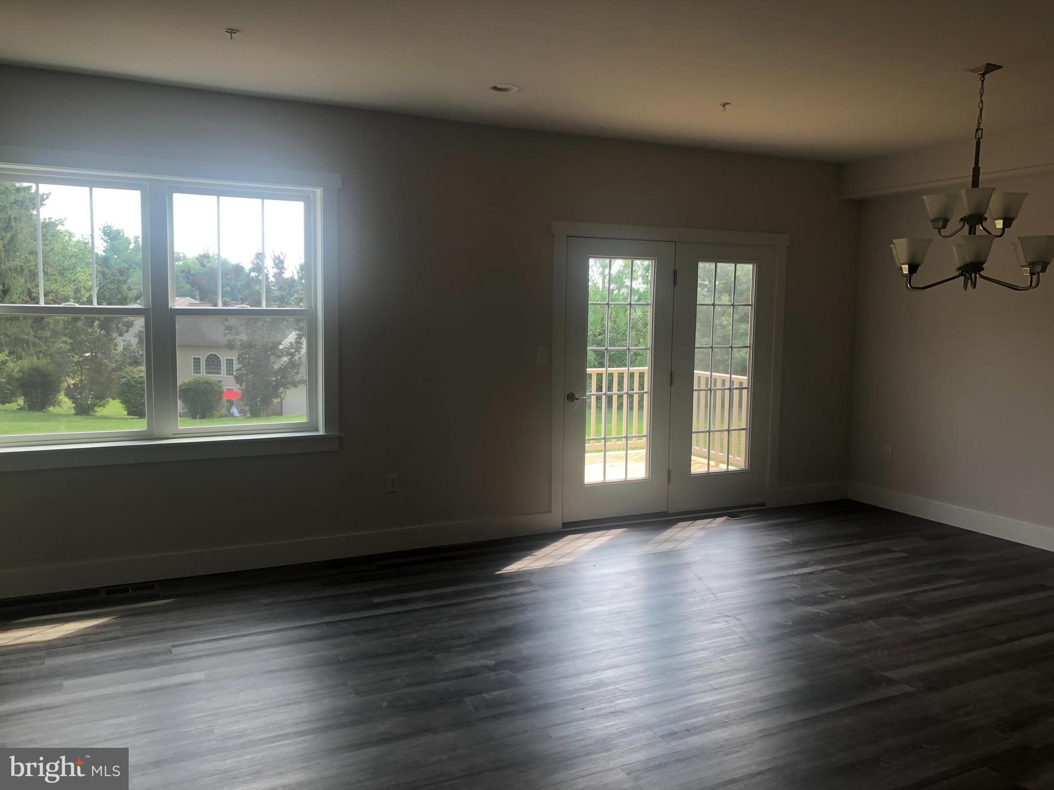 4135 Orrs Town Court, Unit 4B Mechanicsburg, PA 17050 - Photo 19 of 49 an empty room with wooden floor and windows