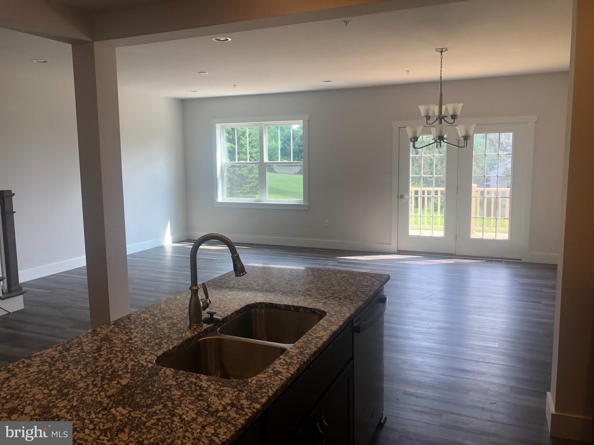 4135 Orrs Town Court, Unit 4B Mechanicsburg, PA 17050 - Photo 21 of 49 a kitchen with kitchen island a sink wooden floor and a large window