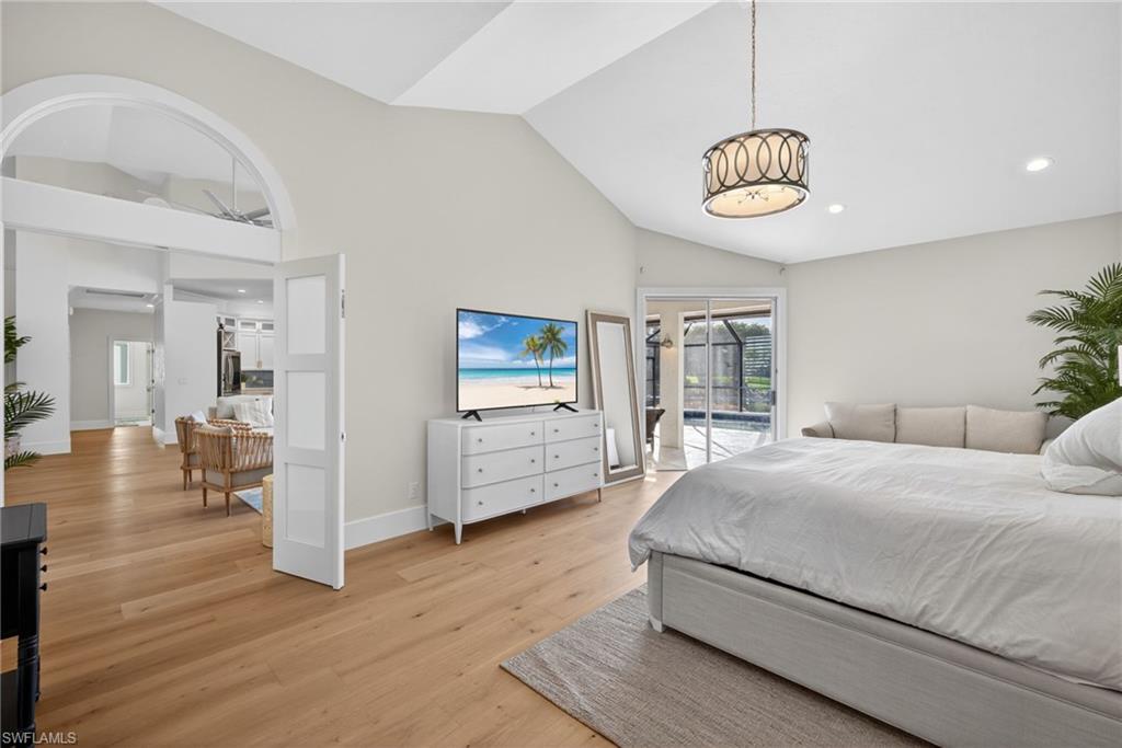 7657 Ponte Verde Way Naples, FL 34109 - Photo 18 of 41 a bedroom with a bed and a chandelier
