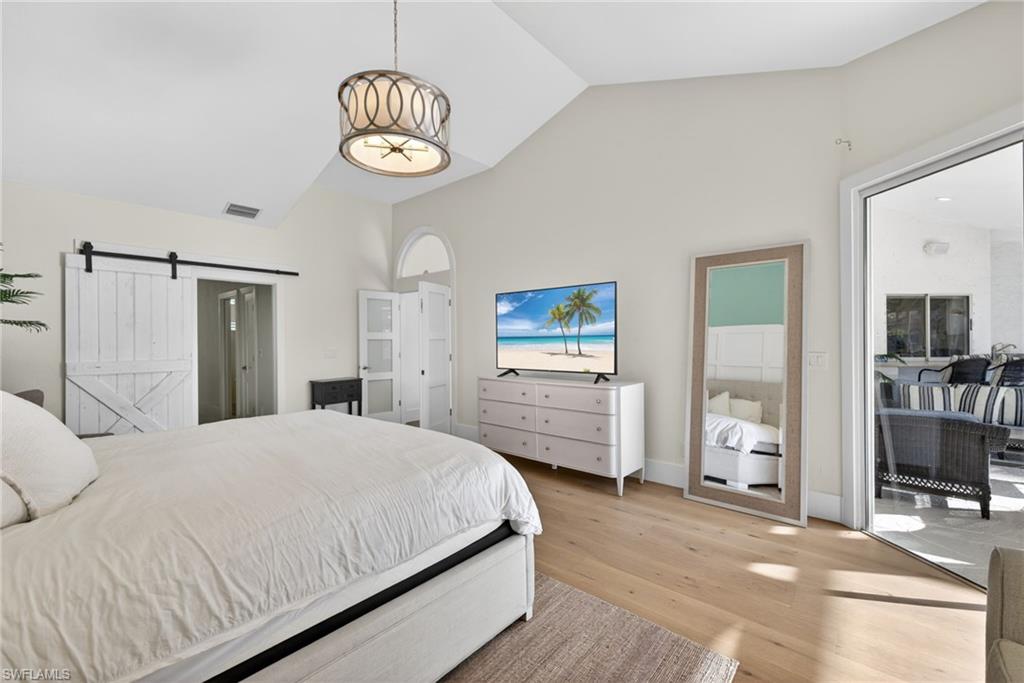 7657 Ponte Verde Way Naples, FL 34109 - Photo 19 of 41 a bedroom with a bed and a chandelier