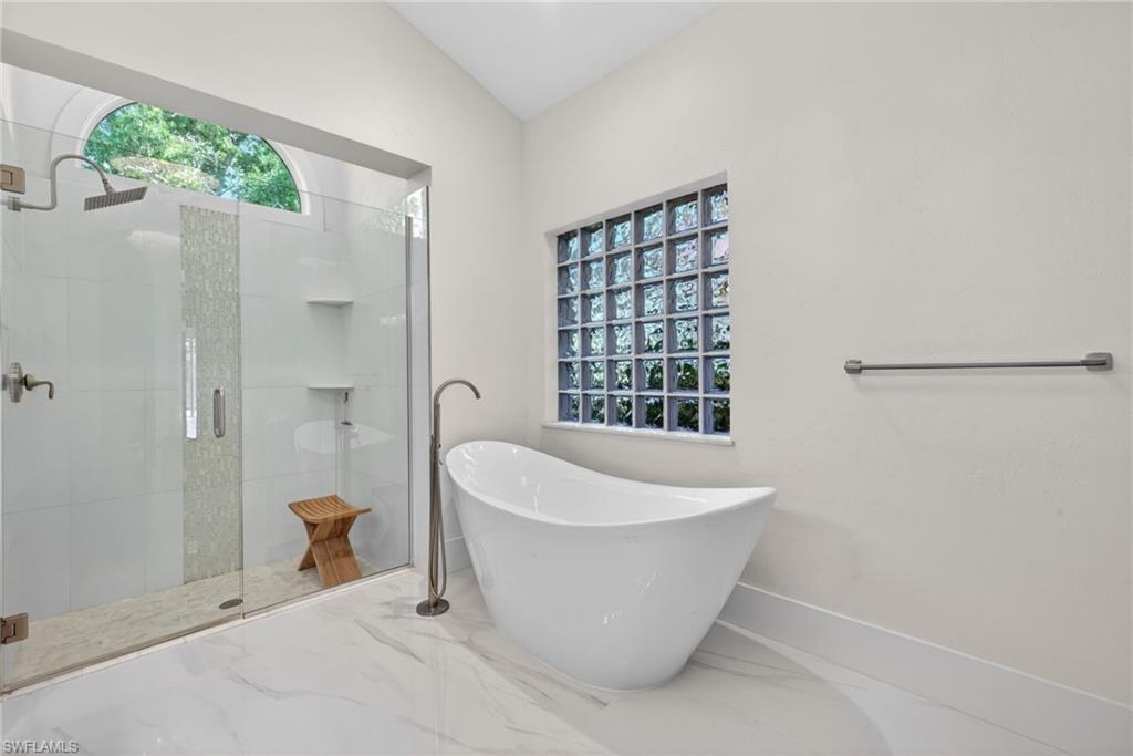 7657 Ponte Verde Way Naples, FL 34109 - Photo 21 of 41 a white bath tub sitting in a bathroom next to a window